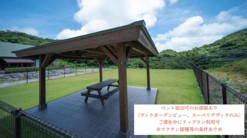 a gazebo with a bench on a patio at Churaumi Village Motobu-Fuji-Karst in Motobu