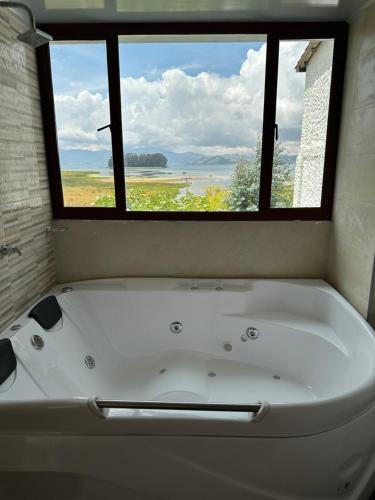 a bath tub in a bathroom with a window at Hotel Rocamonti in Aquitania