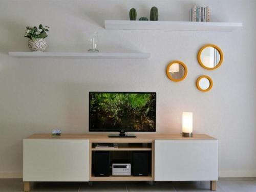a living room with a television on a white cabinet at Apartment by Interhome in Cambo-les-Bains