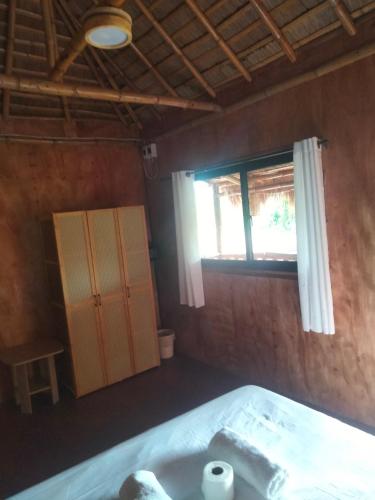 a bedroom with a bed and a window at The Garden Tropical Cabins in Basdiot