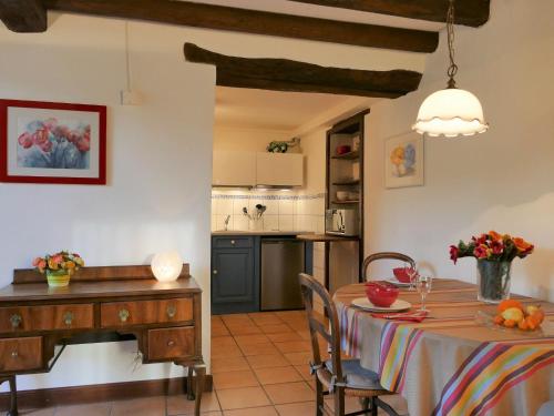 a kitchen and dining room with a table and a desk at by Interhome in Louhossoa