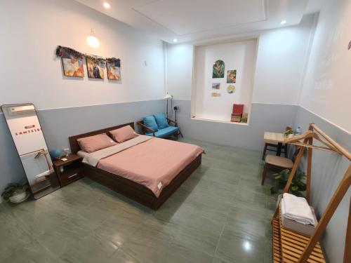 a bedroom with a bed and a chair in it at MOJA HOUSE l Homestay Huế in Thôn Dương Xuân Hạ