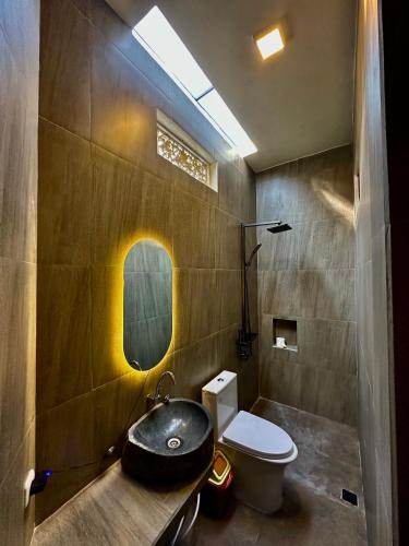a bathroom with a sink and a toilet at Medewi Secret SurfCamp in Pulukan