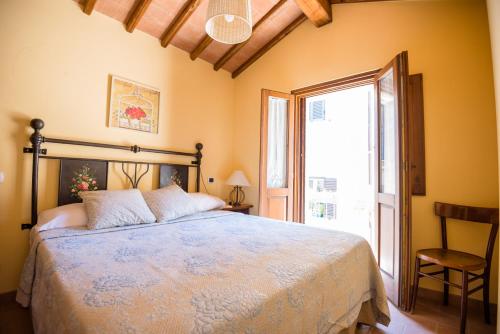 a bedroom with a bed and a large window at BorgoCuore in Todi