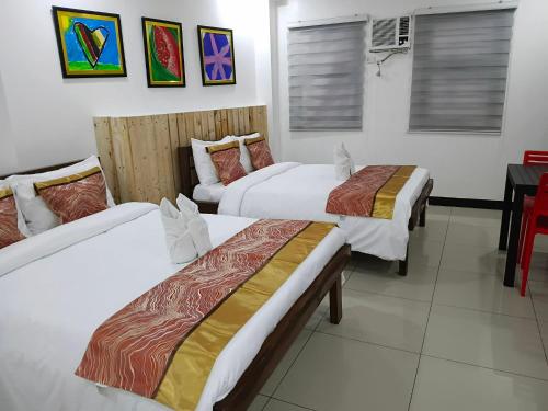 ein Hotelzimmer mit zwei Betten und einem Schreibtisch in der Unterkunft D'Builders Rooms Hotel in Sampong