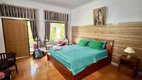 a bedroom with a bed with a wooden head board at The Arya guest house in Gilimanuk