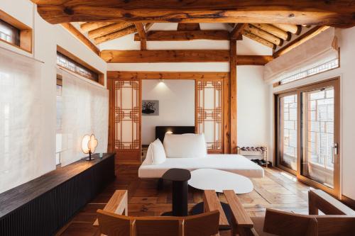 a bedroom with a white bed and wooden ceilings at THE CHAE Premium Hanok Stay in Seoul