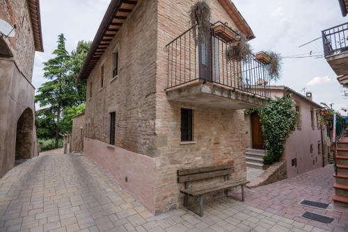 a brick building with a balcony and a bench at BorgoCuore in Todi