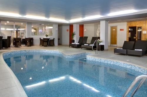 a large swimming pool in a hotel lobby at The Diplomat Hotel Restaurant & Spa in Llanelli