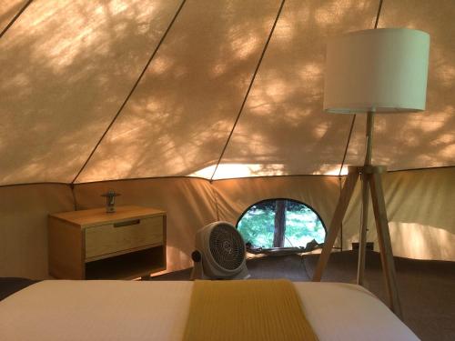 a room with a bed in a tent with a window at Cocuyo Glamping in San Agustín Etla
