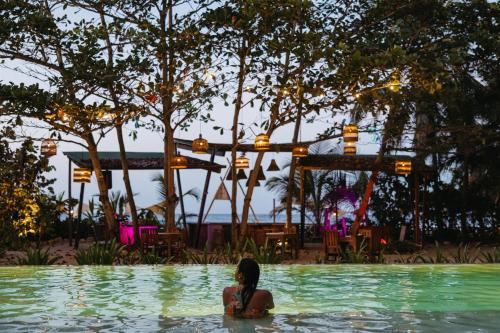 a woman sitting in the water in a swimming pool at Bohemia Beach Tayrona in Guachaca