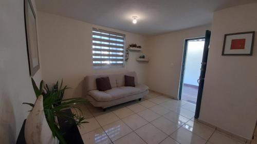 a living room with a couch and a window at Casa centrica y acogedora para tu visita a Hermosillo in Hermosillo