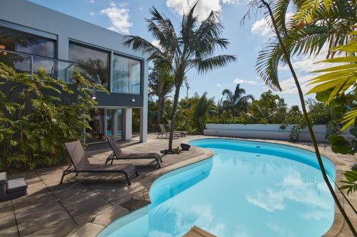 a swimming pool with two chairs and a house at Luxury Retreat with Pool & Views in São Roque