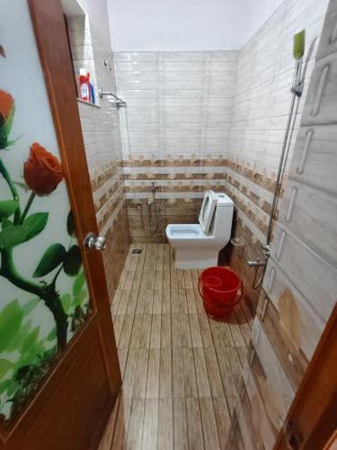 a small bathroom with a toilet and a door at Cozy Nest in Pūvār