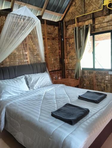 a bedroom with a bed with two towels on it at Bansuan Lanta Maikaew in Ko Lanta