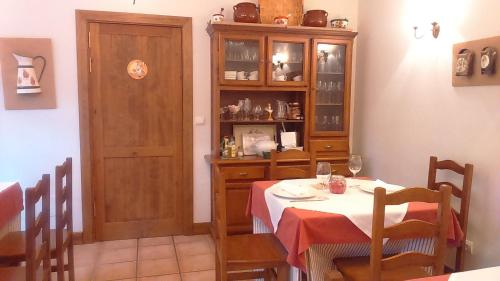 a dining room with a table and a wooden cabinet at Casa Fidela in Lomeña