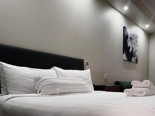 a large white bed with white sheets and pillows at Prince of Wales Hotel in Wagga Wagga
