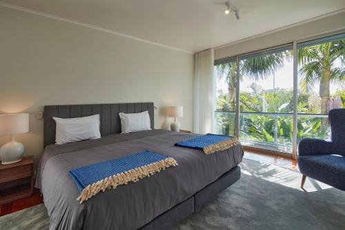 a bedroom with a large bed and a large window at Luxury Retreat with Pool & Views in São Roque