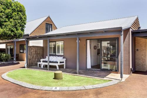 a house with a porch with a grassy yard at Bay Village Dunsborough in Dunsborough