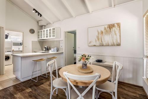a kitchen and dining room with a table and chairs at Bay Village Dunsborough in Dunsborough