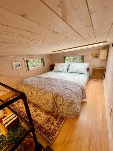 a bedroom with a bed in a tiny house at Forest Nook in Queens Bay