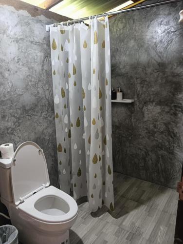 a bathroom with a toilet and a shower curtain at Bansuan Lanta Maikaew in Ko Lanta