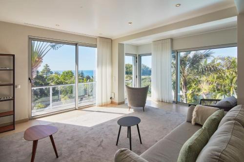 a living room with a couch and large windows at Luxury Retreat with Pool & Views in São Roque