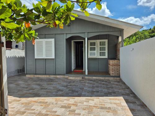 a house with a garage and a driveway at Casa Chalé Ilha Comprida in Ilha Comprida