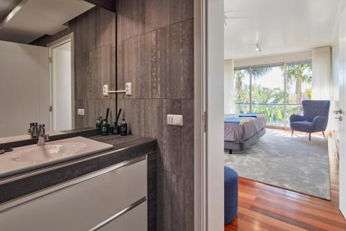 a bathroom with a sink and a view of a bedroom at Luxury Retreat with Pool & Views in São Roque
