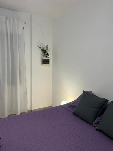 a bedroom with a purple bed and a window at Kallpa in Santa Rosa