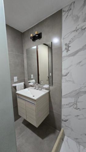 a bathroom with a sink and a mirror at Departamento BARBÚ in Villa María