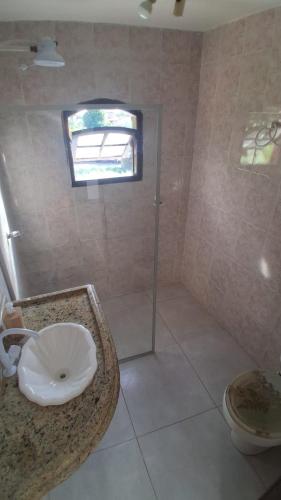 a bathroom with a sink and a shower and a toilet at Casa do Sargento in Saquarema