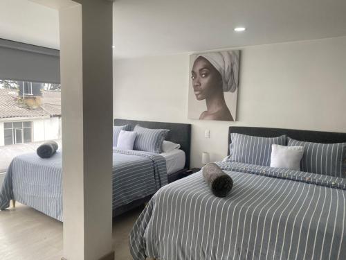 a bedroom with two beds and a painting on the wall at Spacio30 in Bogotá