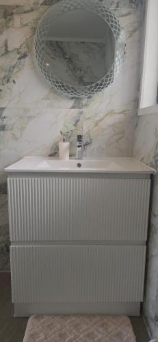 a bathroom sink with a mirror on the wall at Beachfront Bliss in Snells Beach
