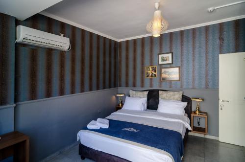 a bedroom with a large bed with blue walls at Ness Hotel in Tel Aviv