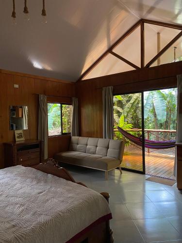 a bedroom with a bed and a couch and windows at Monkey House, Monterrey in San Cristóbal