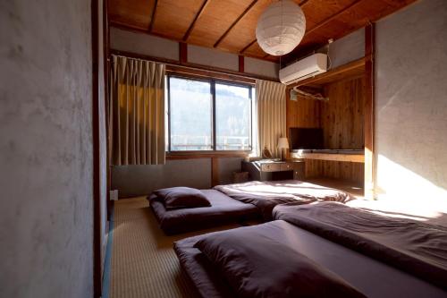 a row of beds in a room with a window at Rebe東吉野 in Higashiyoshino