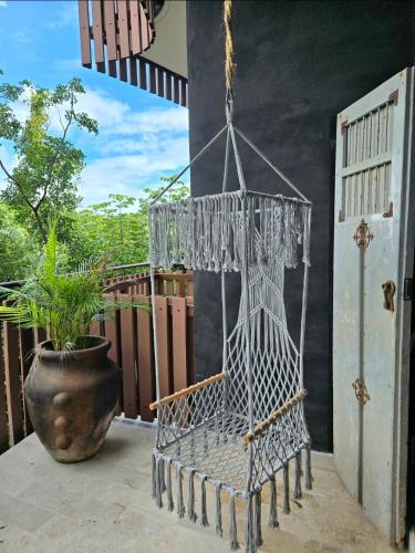a hanging chair on a balcony with a plant at "Designer Cave Loft" in Tulum Hotel Zone - Beach Club included in Tulum