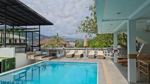 a swimming pool with lounge chairs and a house at Hotel MAMI Resort in Bophut
