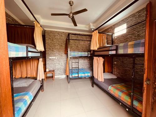 a room with three bunk beds and a ceiling at Puji Bisma Ubud in Ubud