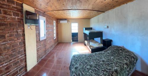 a room with a bed and a brick wall at Casa quinta oro verde in Oro Verde