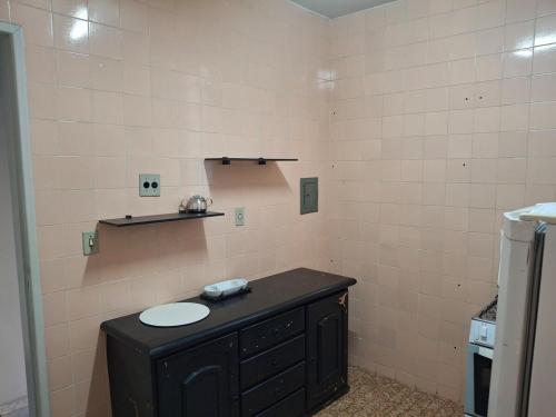 a bathroom with a black counter and a sink at Aconchego II in Juiz de Fora