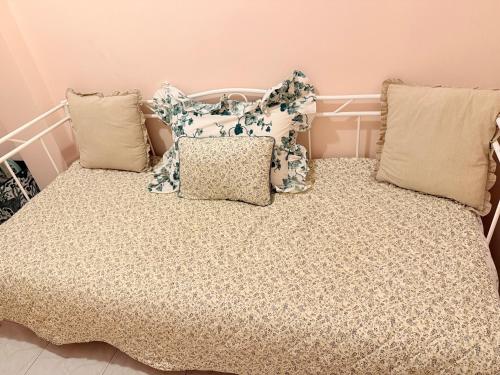 a bed with a bunch of pillows on it at Zeus Beach Condo in Vernardhaíika