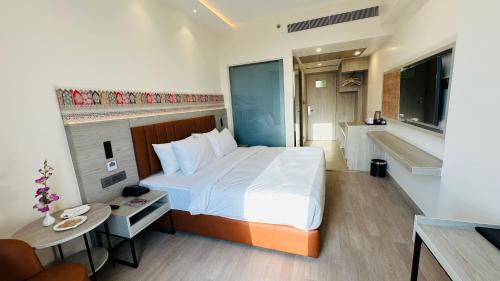 a bedroom with a large bed with a desk and a desk at Regenta Central Jaipur in Jaipur