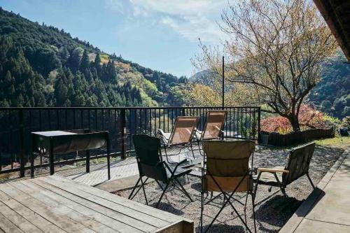 a group of chairs and a table on a deck at Rebe東吉野 in Higashiyoshino