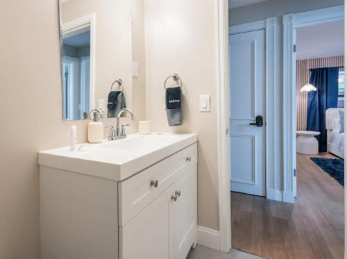 a white bathroom with a sink and a mirror at Biva Luxe in West Palm Beach