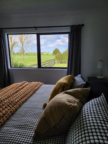 a bedroom with two beds and a large window at Mill Road Retreat Ohaupo in Kaipaki