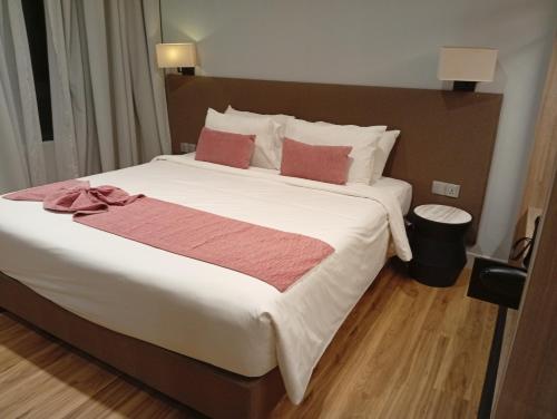 a bedroom with a large white bed with red pillows at Wisma 812 Khusus Putra for Male Only in Bandung