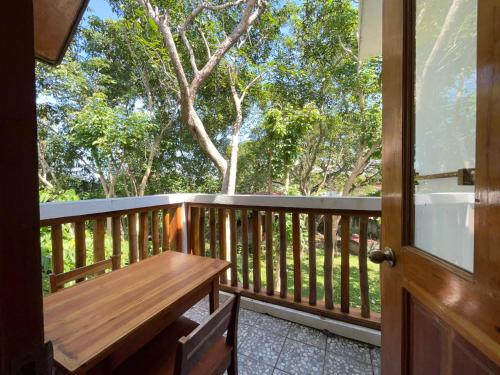 a wooden porch with a wooden bench on a deck at Pahiluna Guesthouse in Panglao Island