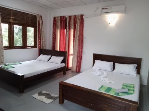 a bedroom with two beds and a window at Wijaya Garden Hotel in Anuradhapura
